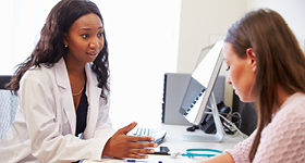 Doctor sitting at desk talking to patient