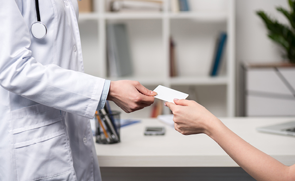 image of a doctor handing a card to a female patient