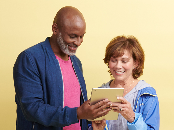 older man and woman looking at a tablet
