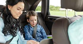 Mother in back seat of car with child
