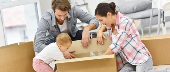 young family unpacking moving boxes