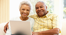 man arm wrapped around woman with laptop