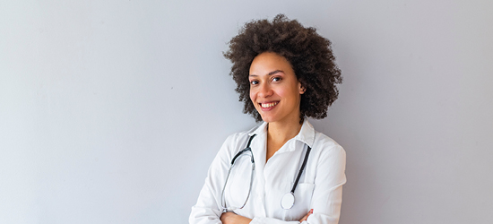 female doctor in white coat against grey background