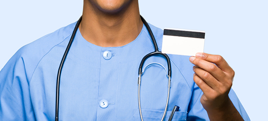 man in blue scrubs holding prescription card