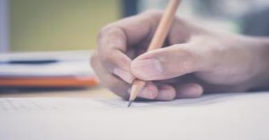 man writing with pencil