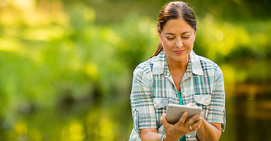 woman on tablet outdoors
