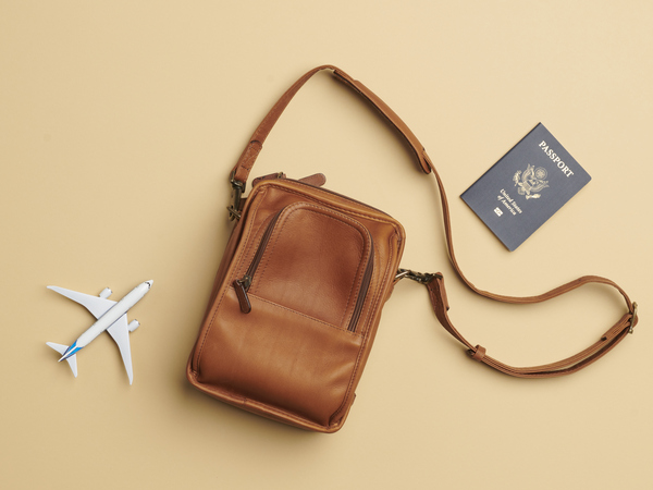 A passport, toy airplane, and a travel bag