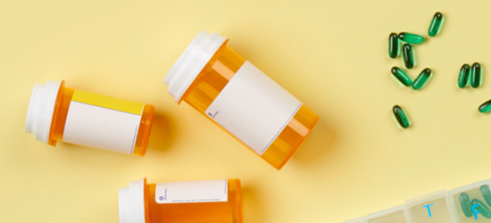 three prescription bottles with green pills