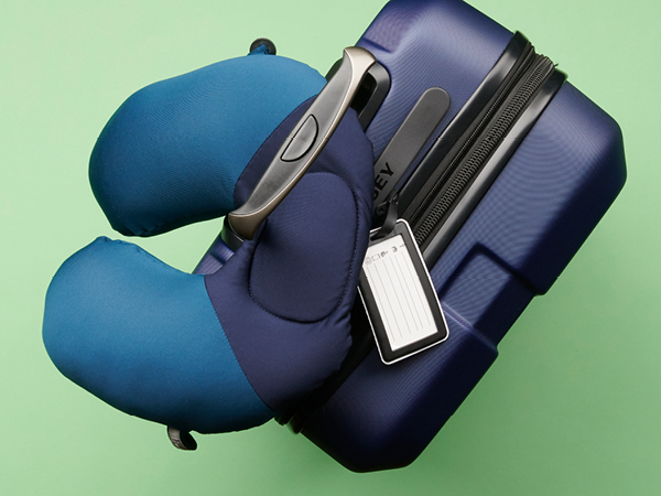 Travel pillow looped through suitcase handle