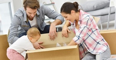 mom, dad and baby opening a box